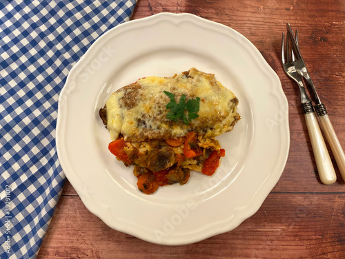 Hearty, stuffed pancakes, also known as Italian crespelle primavera pancakes, filled with vegetables and cheese gratin. Vegetarian food concept.