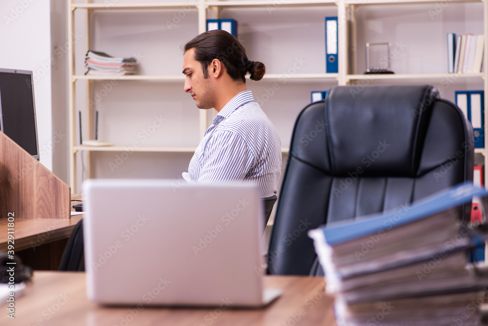 Fototapeta premium Young male employee working in the office