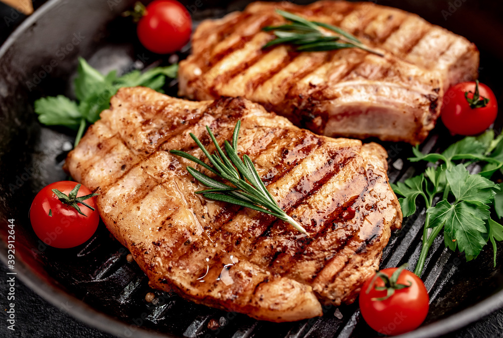 grilled pork steaks in a grill pan with spices

