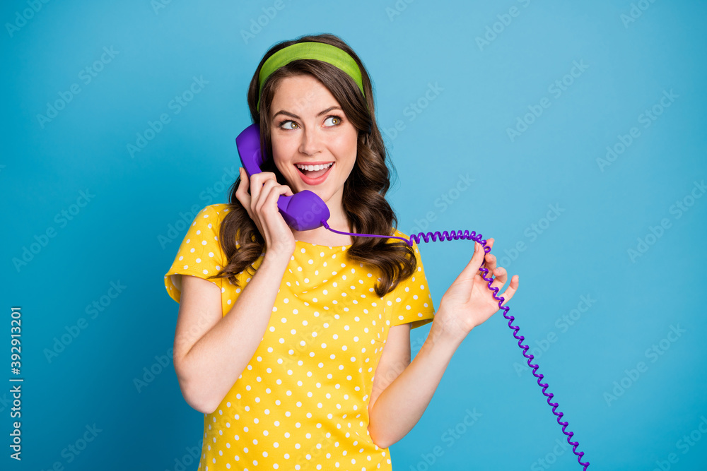 Photo portrait of woman holding wire of purple phone talking isolated on pastel light blue colored background Photo portrait of woman holding wire of purple phone talking isolated on pastel light blue colored background
