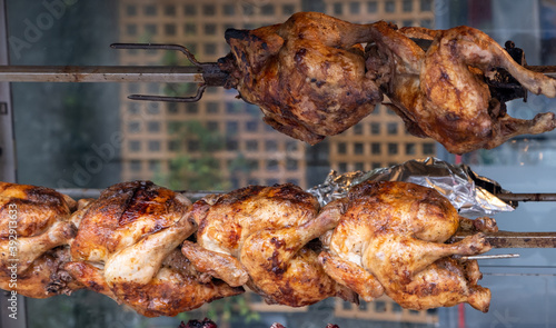 Grilled chickens on skewers, restaurant display on street