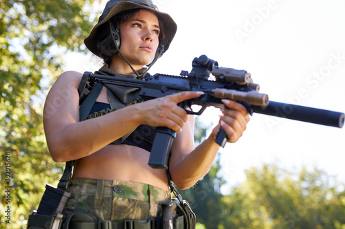 young caucasian hunter woman in top with a gun during the hunt in search of wild birds, in summer or autumn forest during hunting season. the concept of a hobby, killing