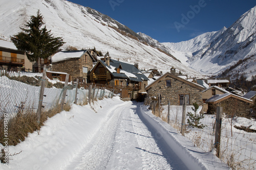 Winter Scene of Road Leading into a Quaint Village with Stone buildings in the French Alps © Athena Images