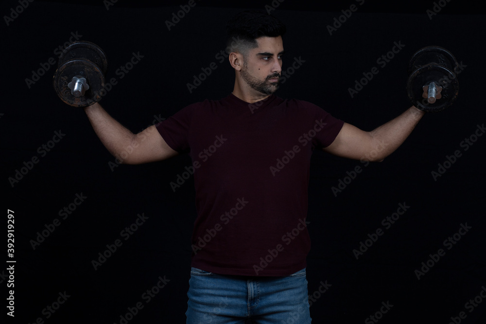 handsome man with dumbbells doing exercises on black background handsome man with dumbbells doing exercises on black background