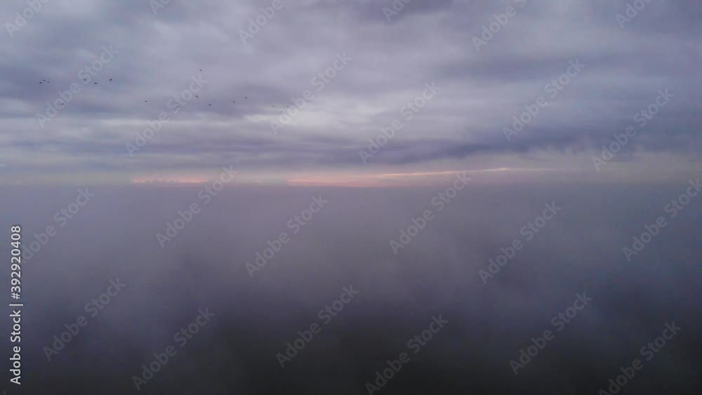 Shot from above the clouds flying down true the clouds at a dutch lake. Pedestal drone shot Shot from above the clouds flying down true the clouds at a dutch lake. Pedestal drone shot