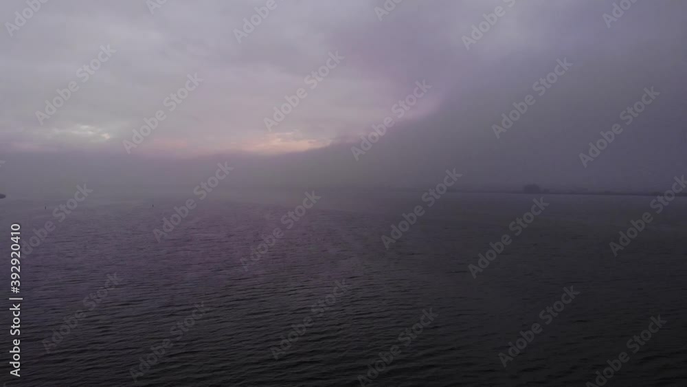 Foggy morning at a lake in the netherlands while the drone is flying above the clouds Foggy morning at a lake in the netherlands while the drone is flying above the clouds