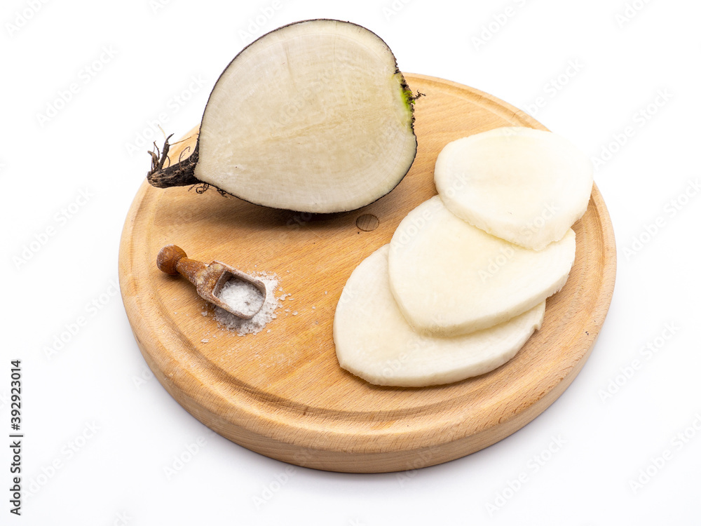 serving idea of sliced black radish on wooden slate with salt serving idea of sliced black radish on wooden slate with salt