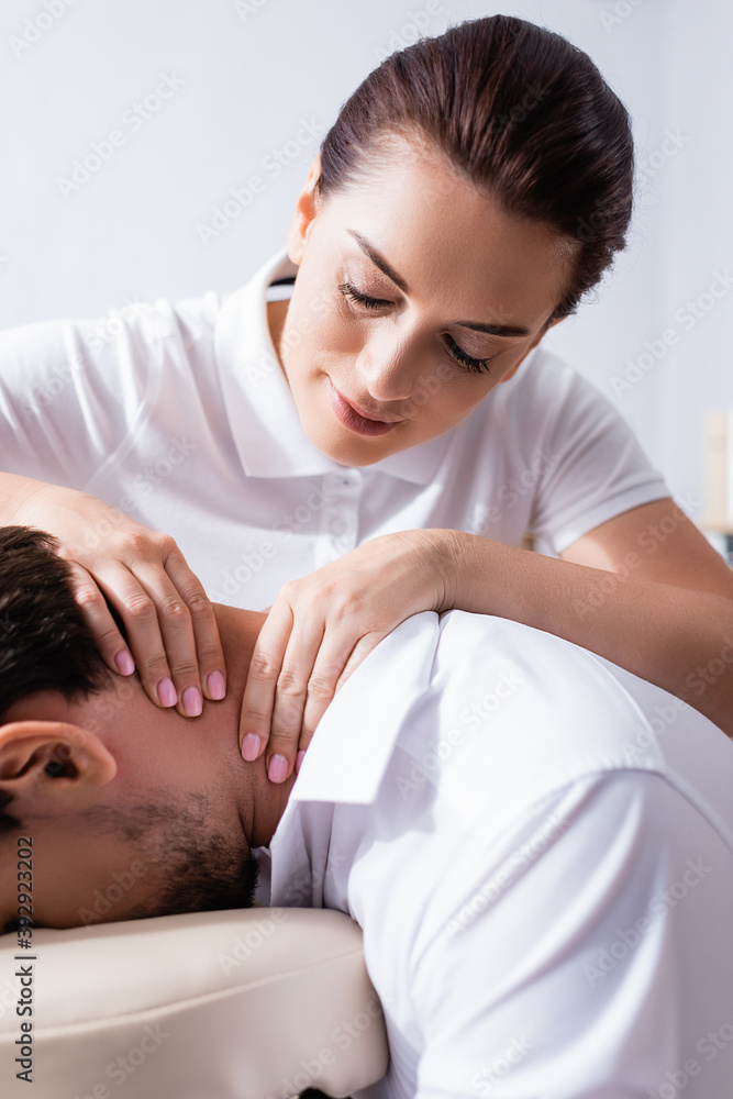 Close up view of positive masseuse doing neck massage for client Close up view of positive masseuse doing neck massage for client