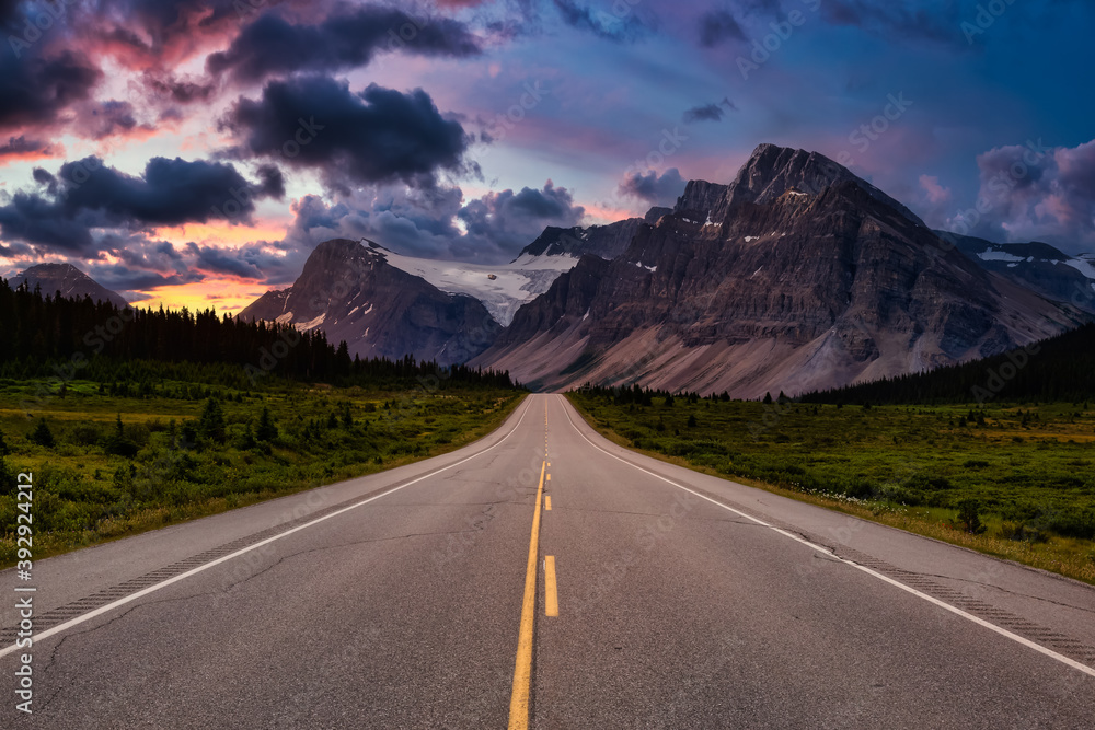 Scenic road in the Canadian Rockies. Dramatic Colorful Sunset Sky. Taken in Icefields Parkway, Banff National Park, Alberta, Canada.