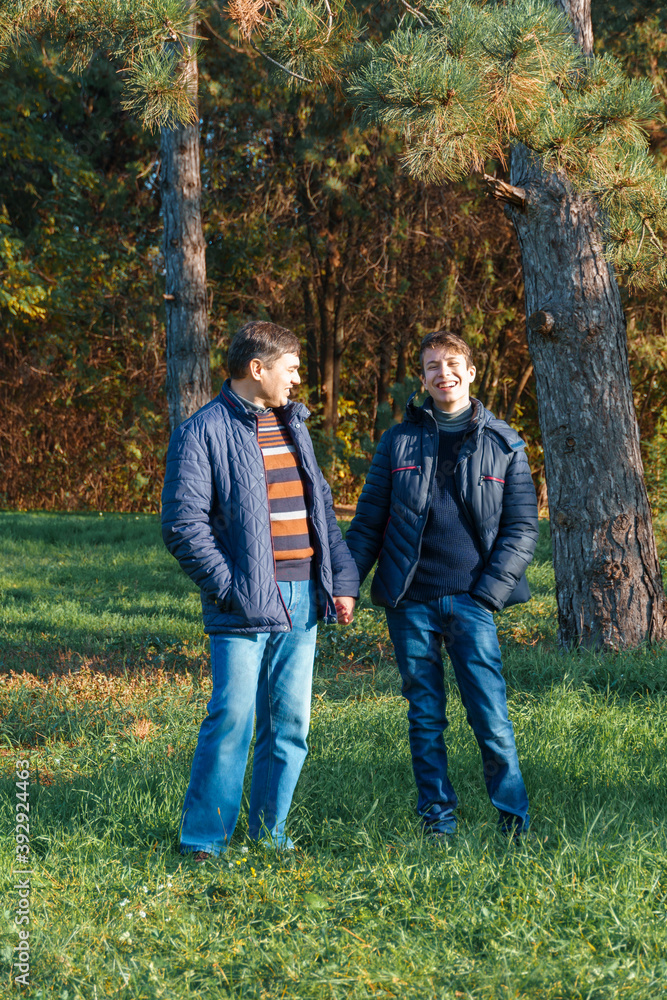 teenager and father posing in autumn park, beautiful nature teenager and father posing in autumn park, beautiful nature