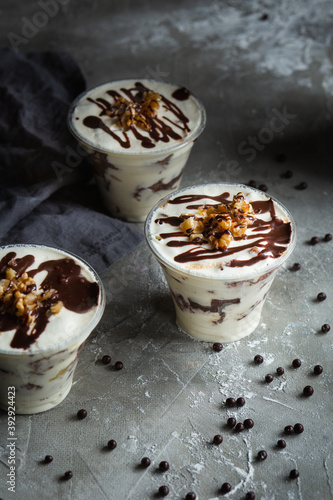 tiramisu in a glass on a gray background with coffee beans