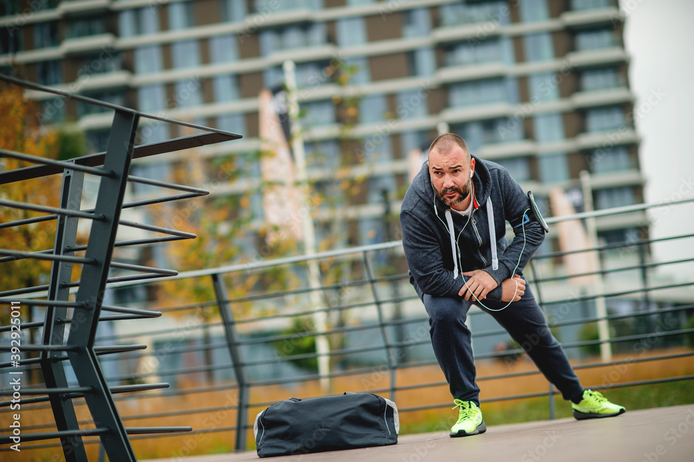Obraz premium Young jogger taking break from exercising outdoors