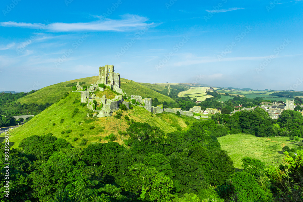 Corfe Castle ruins near Wareham in Dorset, England in the Summer with a clear blue sky and soft white clouds