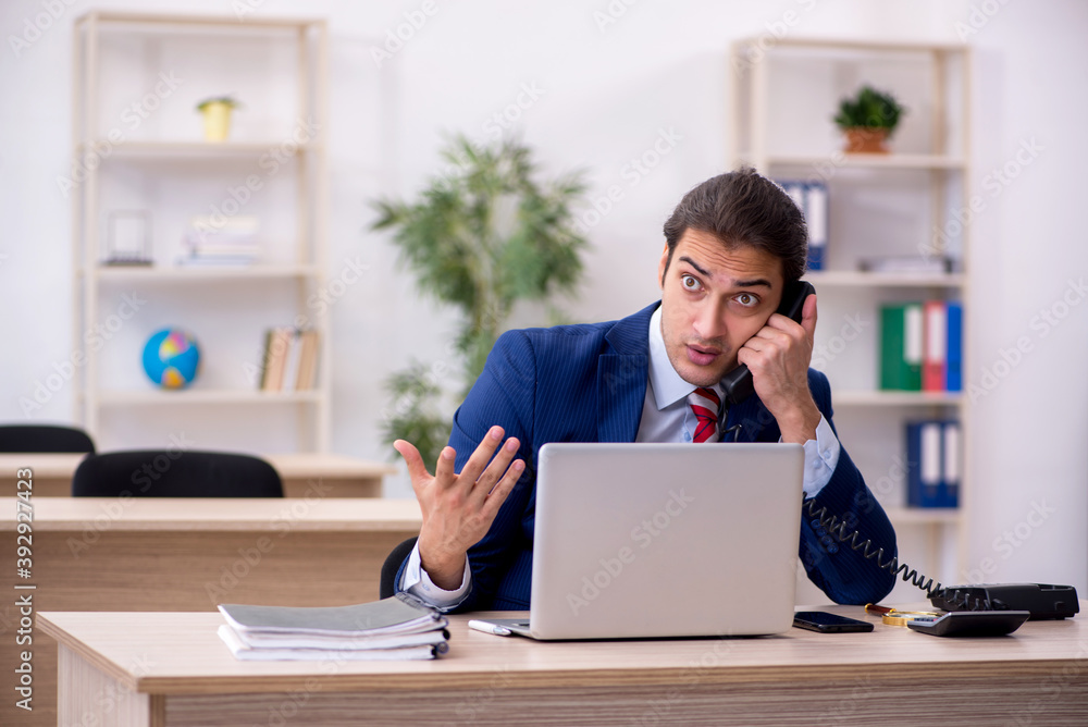 Young male employee sitting in the office Young male employee sitting in the office