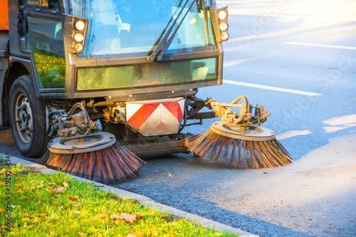 Cleaning leaves with a road brush in autumn.