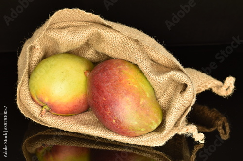 ripe organic mango, close-up, on a black background.