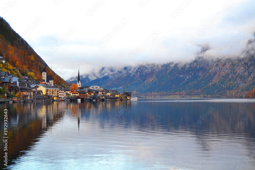Hallstatt town view in a foggy day and clouds between the mountains. Amazing autumn cityscape, Austria, Salzkammergut
