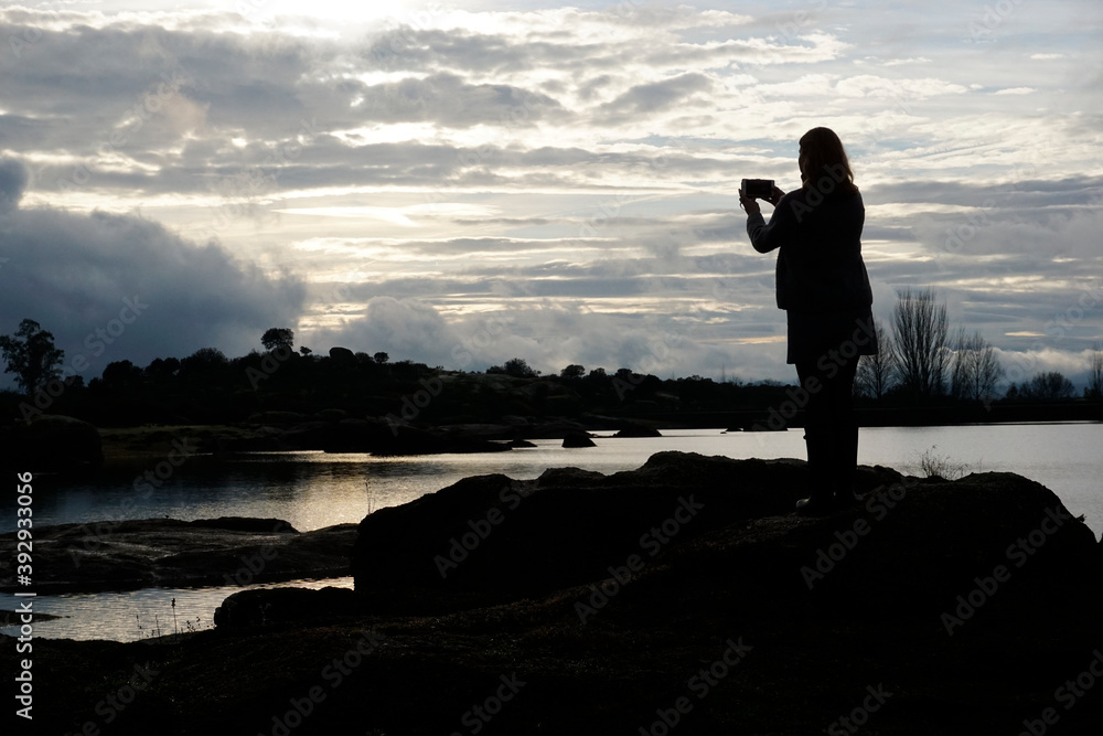 Woman taking photos in Los Barruecos, granite formations and ponds with great animal diversity in a natural monument in Extremadura