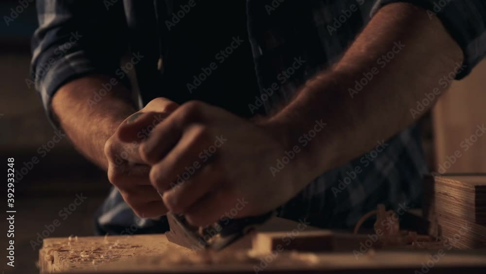 Carpenter cutting off wooden shavings with jointer Carpenter cutting off wooden shavings with jointer