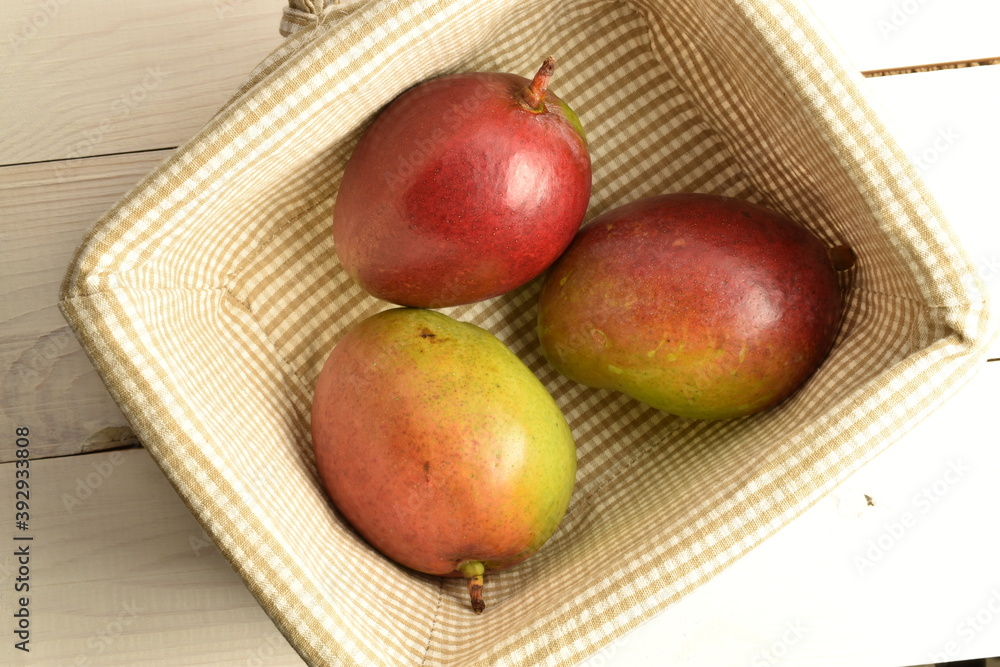 ripe mangoes, close-up, on a white wooden table. ripe mangoes, close-up, on a white wooden table.