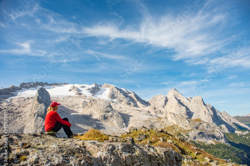 Sporty young woman relaxing on mountain trail Marmolada, Dolomites Mountains, Italy. Sport, success, inspiration