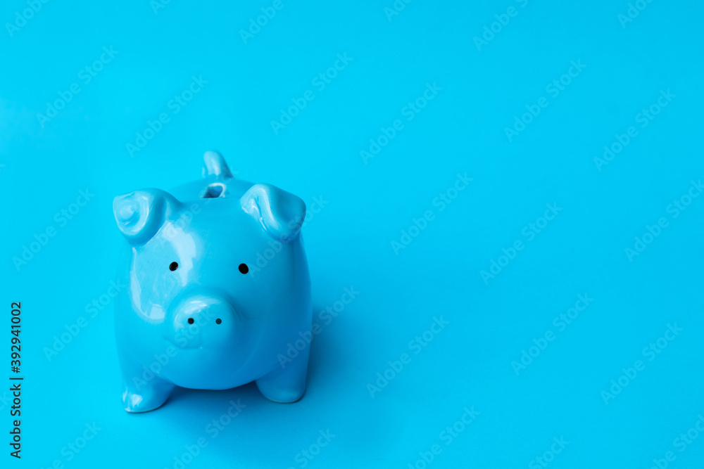 Blue piggy bank smile isolated on blue background. Finance, saving money concept. Blue piggy bank smile isolated on blue background. Finance, saving money concept.