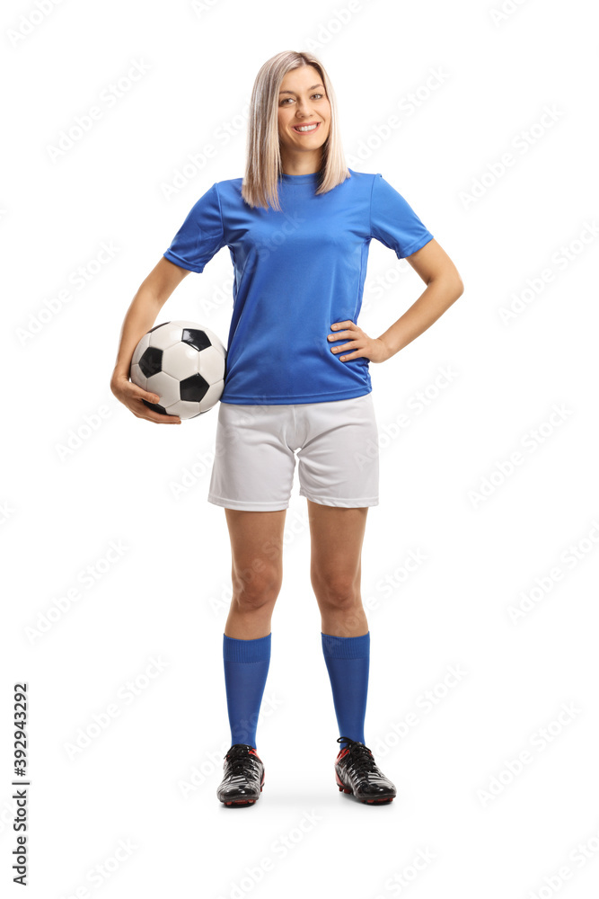 Full length portrait of a woman football player smiling and holding a ball