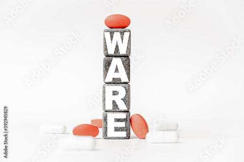 a group of white and red pills and cubes with the word ware on them, white background. Concept carehealth, treatment, therapy. photo