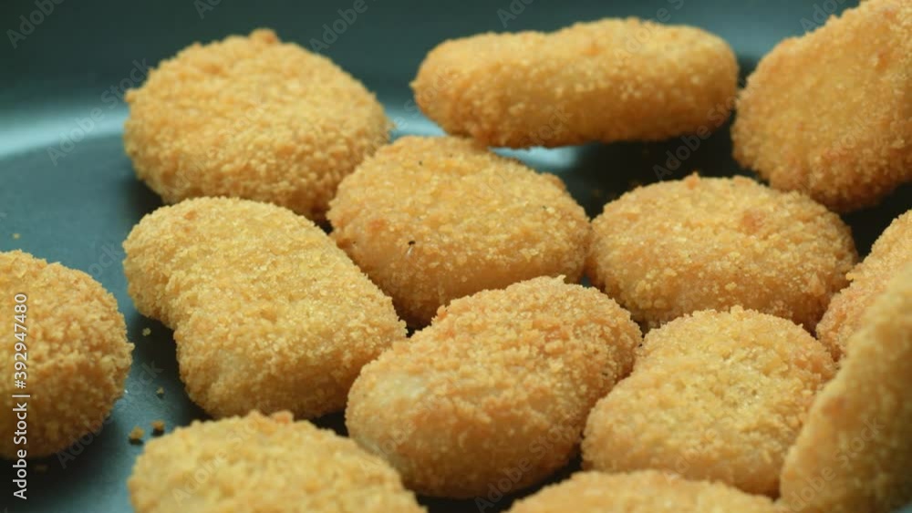 Close-up of delicious golden nuggets mixed in a pan during frying. The concept of delicious home junk food. Slow motion Close-up of delicious golden nuggets mixed in a pan during frying. The concept of delicious home junk food. Slow motion