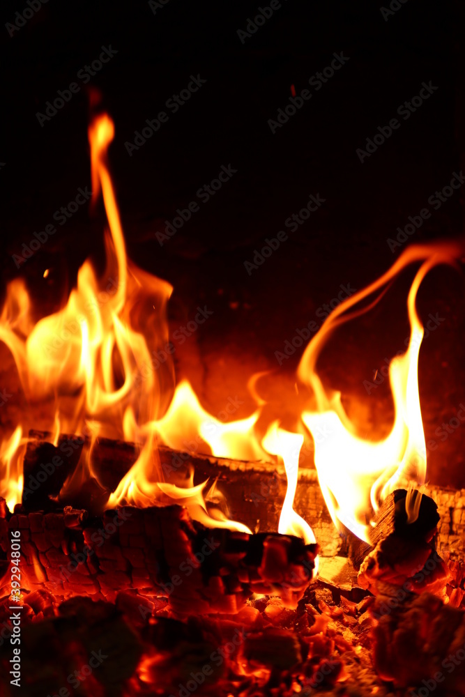 Wood is burning in the fireplace. Home comfort. Vertical orientation Wood is burning in the fireplace. Home comfort. Vertical orientation