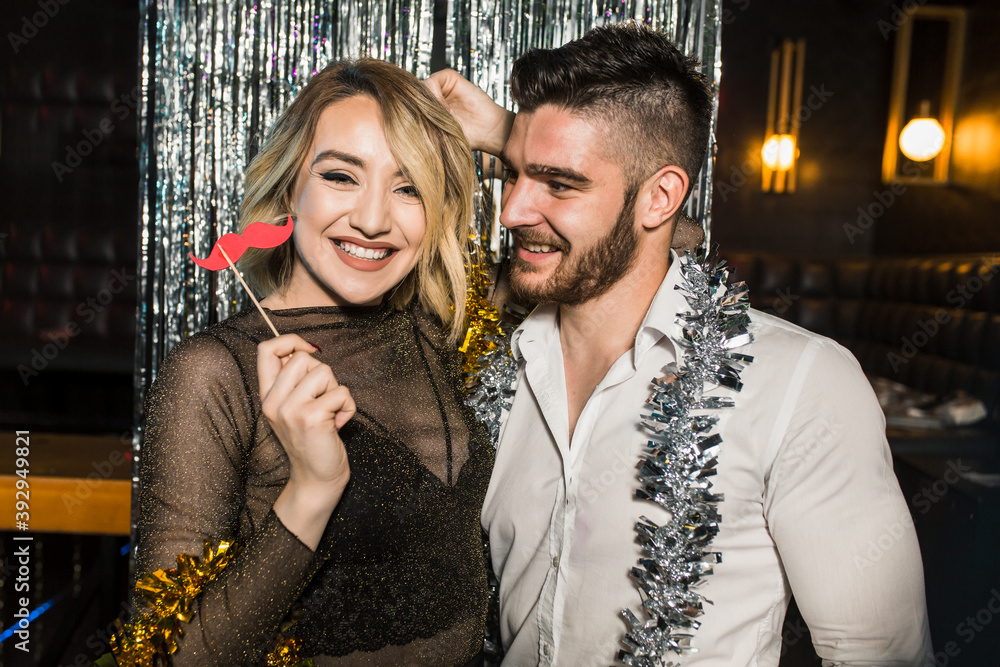 Portrait of happy young couple posing together at nightclub Portrait of happy young couple posing together at nightclub