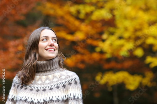 Happy woman looks at side in a park in autumn