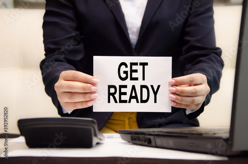 get ready text is written on a white sheet of paper held by a business girl