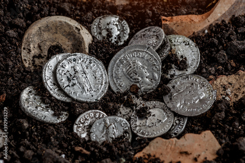 Ancient coin of the Roman Empire.Authentic silver denarius, antoninianus of ancient Rome.Roman silver coins covered in dirt.Antikvariat. photo