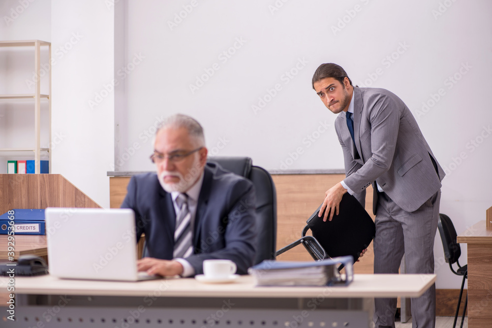 Old boss and young male assistant in the office Old boss and young male assistant in the office