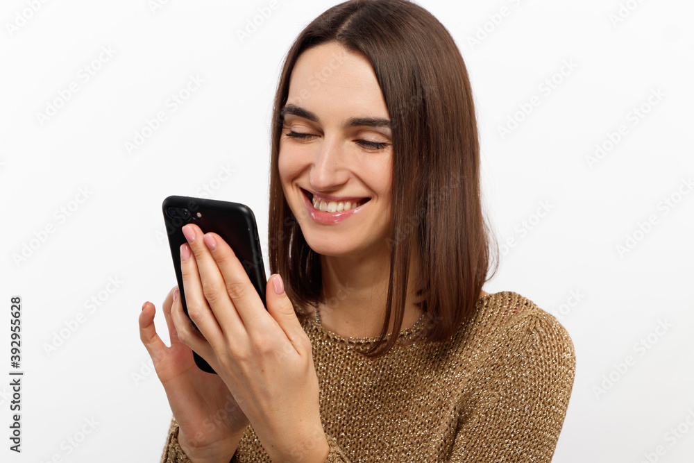Front portrait of young smiling woman using mobile phone against white background Front portrait of young smiling woman using mobile phone against white background