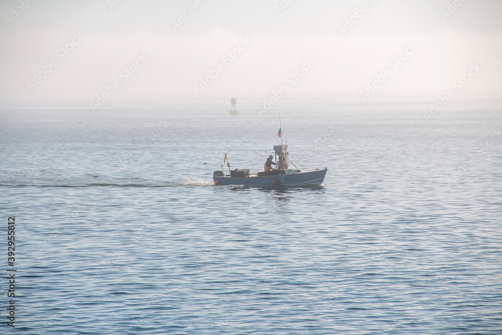 Fisherman’s boat going across the ocean on a foggy day Fisherman’s boat going across the ocean on a foggy day