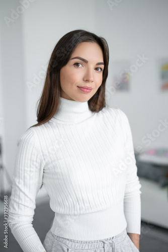 Portrait of a woman in a white sweatshot in the interior.