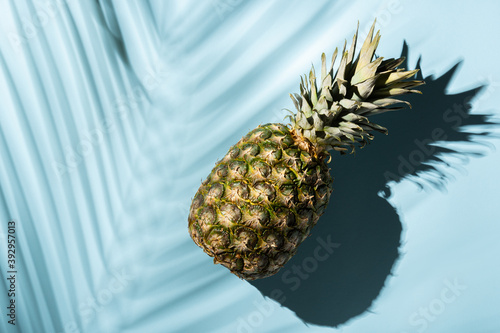 Pineapple and tropical palm leaves on blue background.Top view