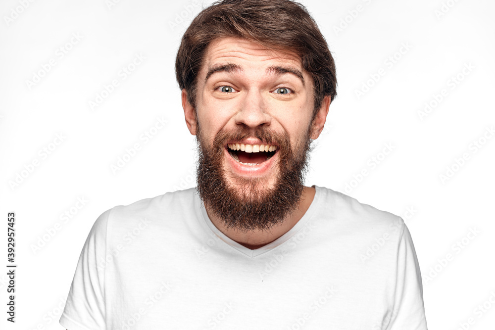 cheerful emotional bearded man gesturing with his hands close-up light background cheerful emotional bearded man gesturing with his hands close-up light background