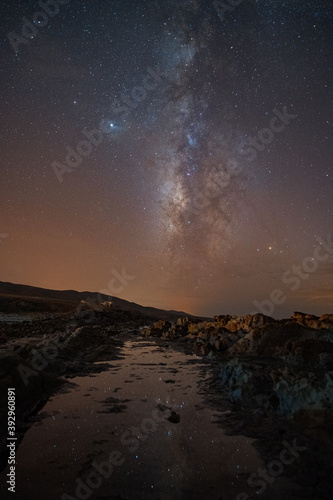 Milky way reflected in a sea puddle