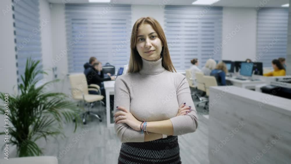 Portrait of happy office worker looking at camera in modern office, positive female employee with smiling face satisfied with good job career, close up portrait in slow motion Portrait of happy office worker looking at camera in modern office, positive female employee with smiling face satisfied with good job career, close up portrait in slow motion