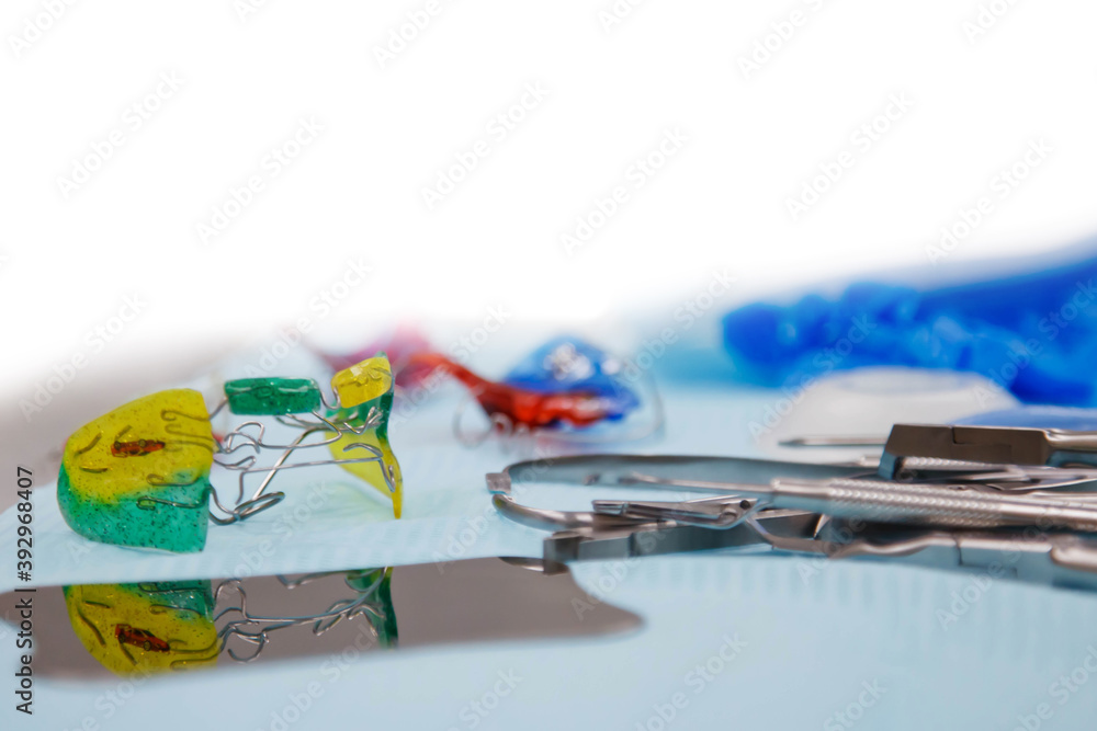 Dental instruments and dentures on medical table. Laboratory instruments for treatment and model of teeth on blue background. Prosthetist's office. Concept of examination to hygienist. Copy space