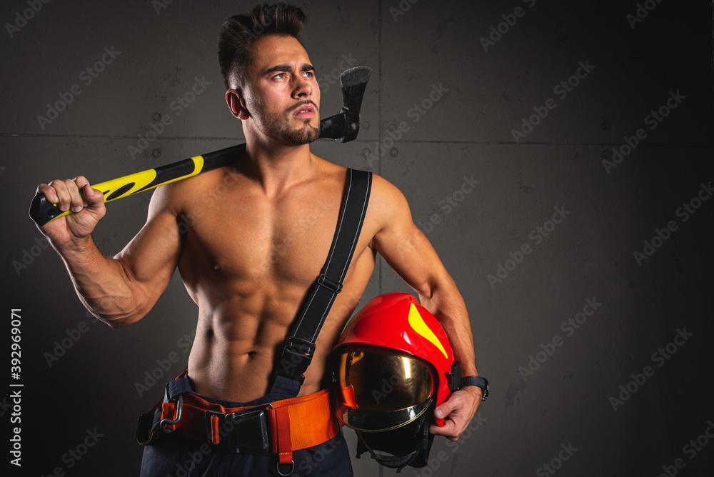 Fashionable portrait of a young man in fire equipment on a black studio