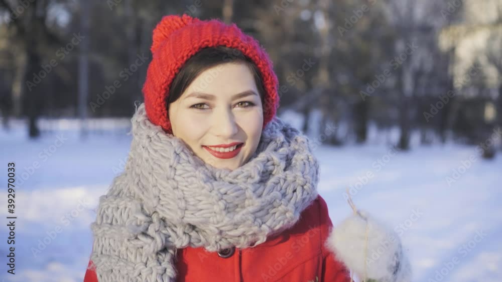 Pretty girl outside enjoying cold snowy winter. Beautiful asian mixed race woman in red winter hat and coat holding christmas wreath and smiling. Merry xmas and happy new year concept. Pretty girl outside enjoying cold snowy winter. Beautiful asian mixed race woman in red winter hat and coat holding christmas wreath and smiling. Merry xmas and happy new year concept.