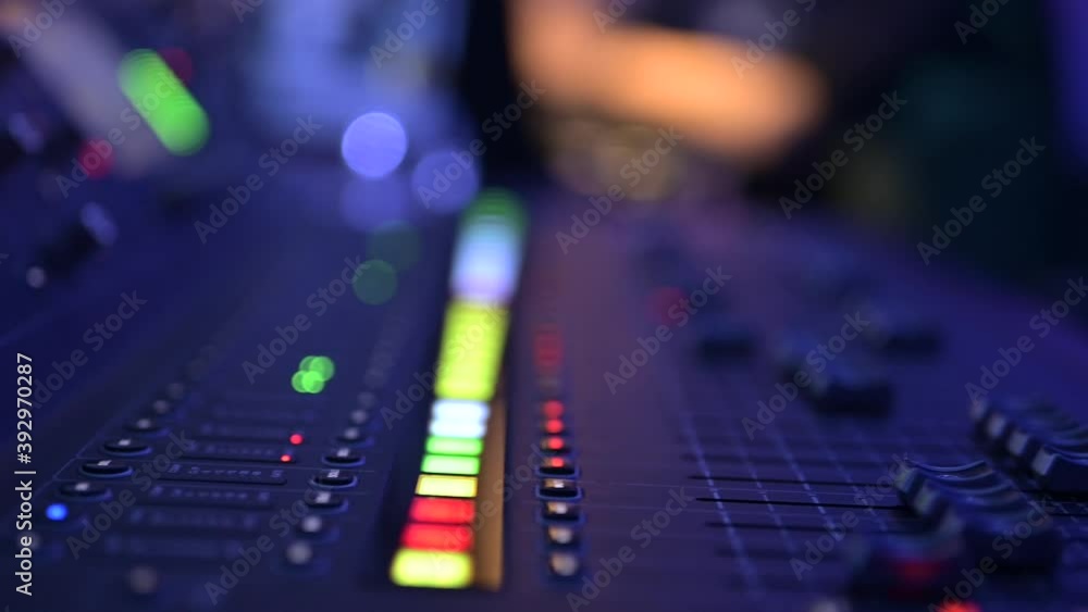 Professional sound mixing console, audio mixer, board, mixing deck or mixer closeup. Faders and buttons with flashing lights on activated channels. Music studio production and event sound engineering Professional sound mixing console, audio mixer, board, mixing deck or mixer closeup. Faders and buttons with flashing lights on activated channels. Music studio production and event sound engineering