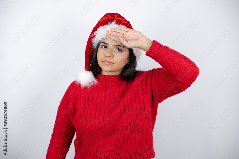 Young beautiful woman wearing a Santa hat over white background Touching forehead for illness and fever, flu and cold, virus sick Young beautiful woman wearing a Santa hat over white background Touching forehead for illness and fever, flu and cold, virus sick