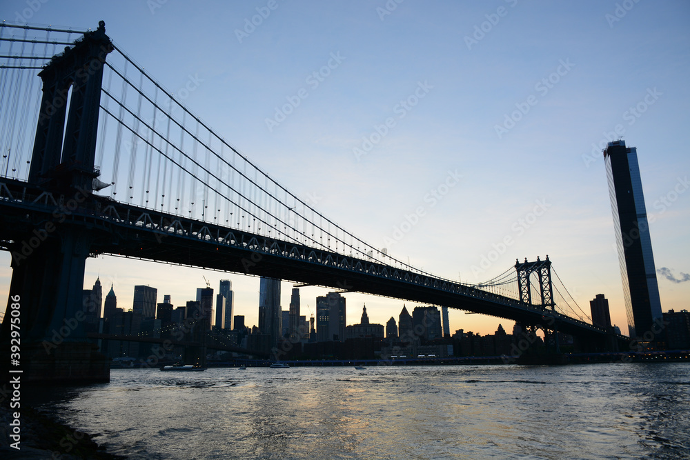 Obraz premium Brooklyn, USA - May 27, 2019: Sunset view to Manhattan from Main Street Park near Brooklyn Bridge