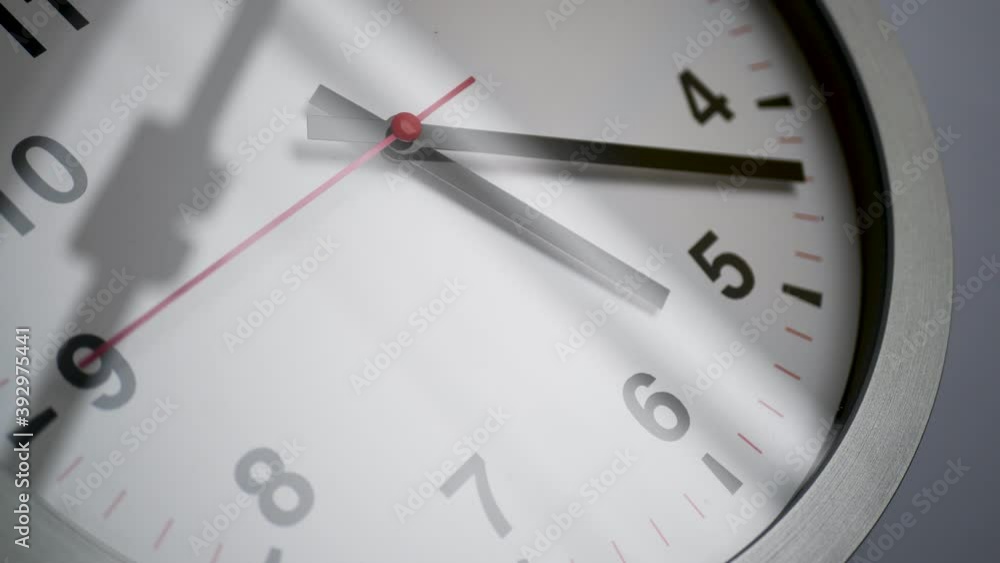 Close up of a ticking clock on white background, window reflection Close up of a ticking clock on white background, window reflection