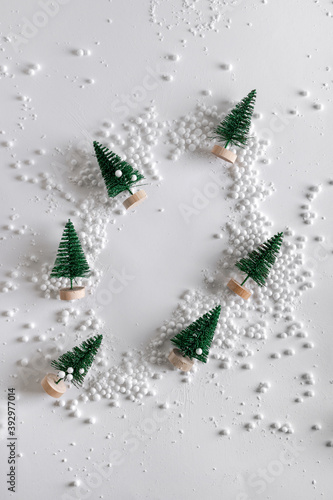 Christmas trees in the snow in the shape of a circle. New Year's decor. Snowflakes and snowball on a white background.Christmas, winter, new year concept.